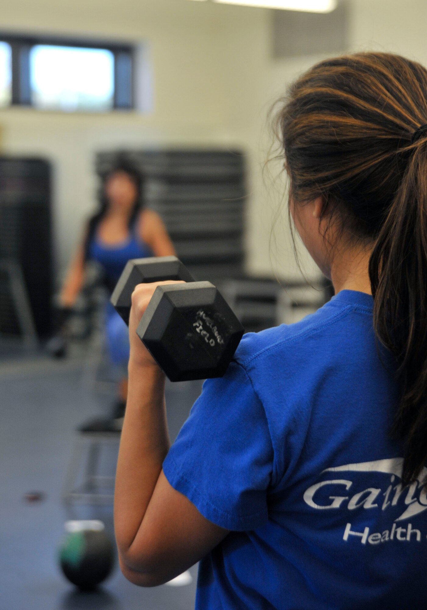 Arielle Vasquez, Full Body Sculpt Class student, lifts weights during a circuit-formation exercise at Hurlburt Field, Fla., Jan. 23, 2014. The Aderholt Gym offers the class on Tuesdays and Thursdays at 9:30 a.m. (U.S. Air Force photo/Airmen 1st Class Andrea Posey)