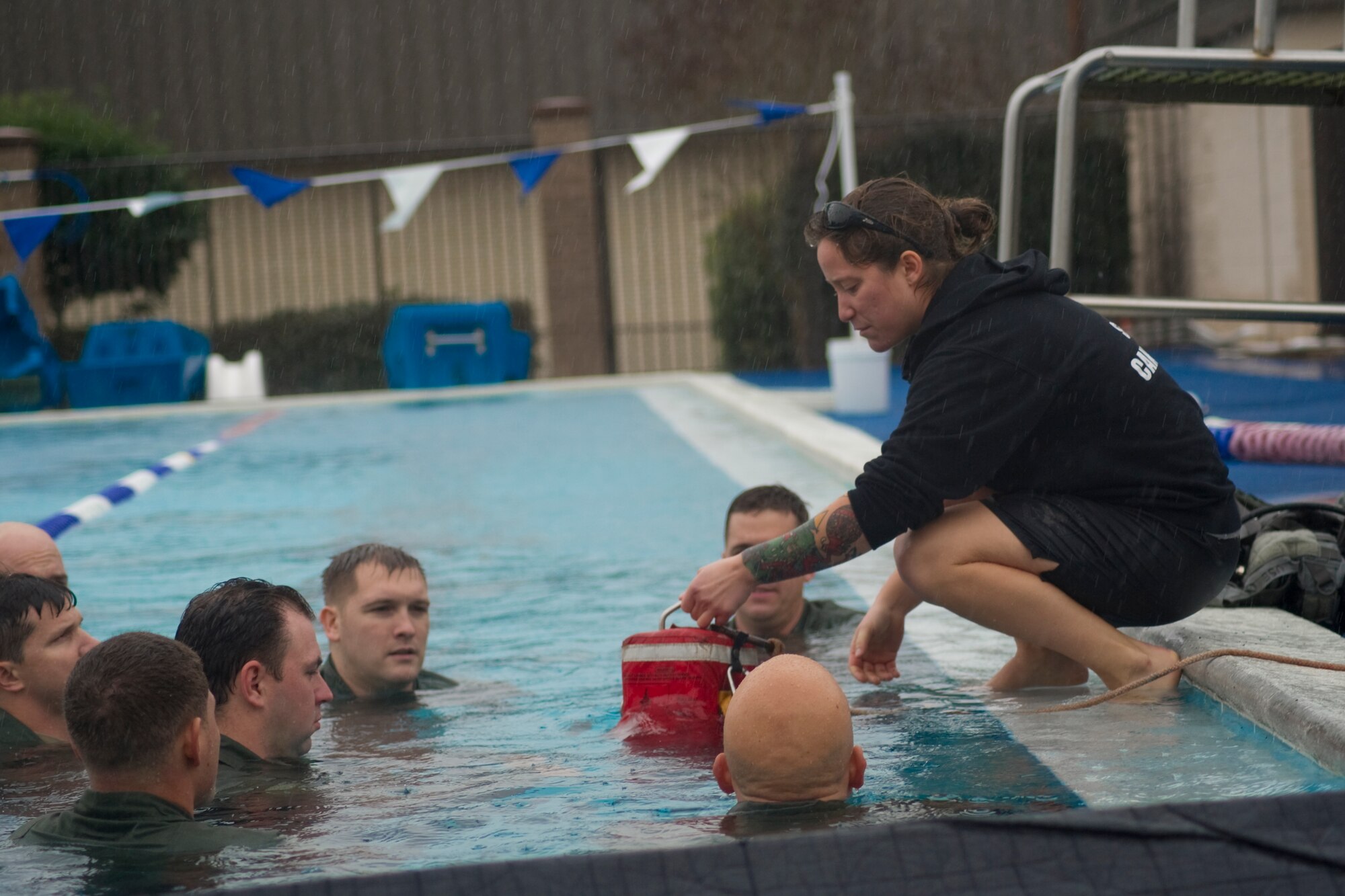 Senior Airman Charlene Plante, 1st Special Operations Support Squadron survival, evasion, resistance and escape instructor, teaches aircrew members the proper way to escape a rotary- wing aircraft during a SERE refresher course at base pool at Hurlburt Field, Fla., Jan. 27, 2014. Aircrew are instructed on the available resources onboard the aircraft that can potentially serve as lifesaving devices. (U.S. Air Force photo/Senior Airman Naomi Griego)