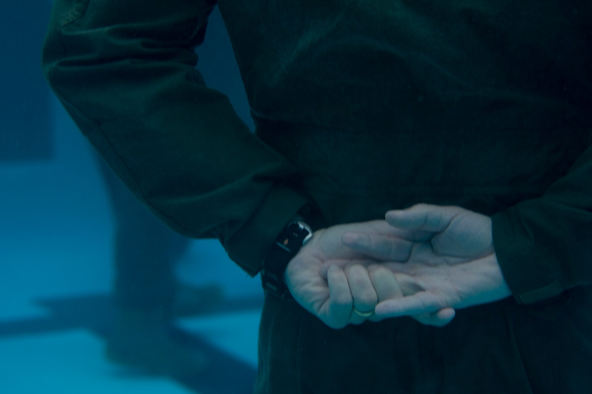 An aircrew member holds his hands underwater while awaiting instructions during a water survival refresher course at the base pool at Hurlburt Field, Fla., Jan. 27, 2014. In order to successfully complete the course aircrew must tread water for 5 minutes and escape a simulated aircraft seat apparatus while submerged underwater. (U.S. Air Force photo/Senior Airman Naomi Griego)