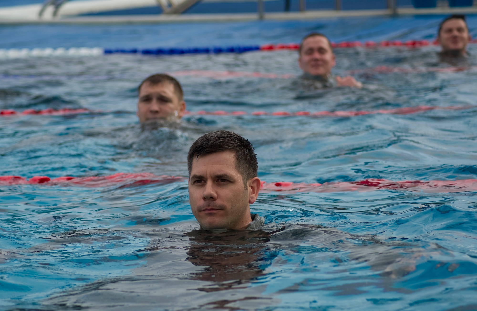 Airmen tread water during a water-survival refresher course in the base pool at Hurlburt Field, Fla., Jan. 27, 2014. The aircrew must tread water for five minutes before successfully escaping a simulated rotary-wing aircraft submerged in water. (U.S. Air Force photo/Senior Airman Naomi Griego)