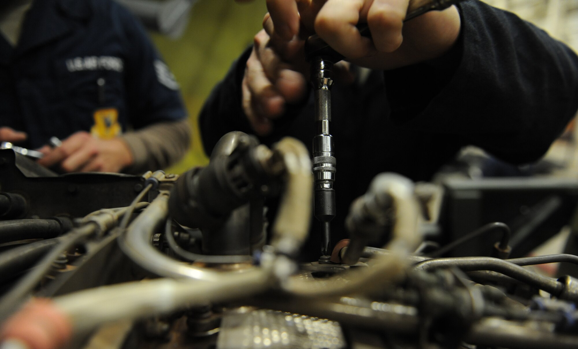 Airmen from the 718th Aircraft Maintenance Squadron loosen screws and bolts on a CFM56 engine during a Mission Focused Exercise on Kadena Air Base, Japan, Jan. 28, 2014. Designed to test Airmen?s skills and readiness in preparation for real-world contingencies, MFEs are essential to ensuring Airmen are prepared for any contingency operations in the Pacific theater.  (U.S. Air Force photo by Airman 1st Class Keith James)