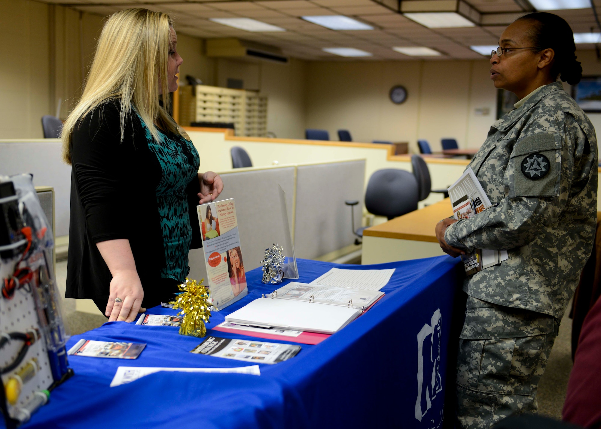 U.S. Army Master Sgt. Kimberly Byers, 93rd Signal Brigade information technology specialist, speaks with Shelby Simmons, Martinsburg College representative, during an Army Career and Alumni Program career expo at Fort Eustis, Va., Jan. 22, 2014.  Career expos are held monthly, and are aimed at preparing transitioning Service members for life in the civilian sector. (U.S. Air Force photo by Staff Sgt. Ciara Wymbs/Released)