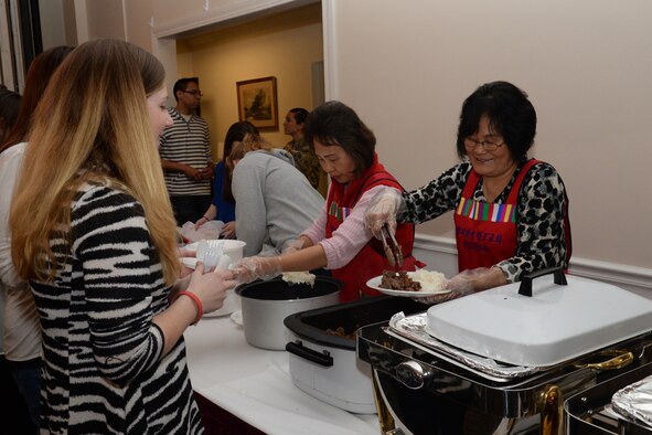 Volunteers from the Korean Presbyterian Church, Sumter, S.C., serve dinner to the families of deployed Shaw Airmen at the Carolina Skies Club and Conference Center during the 20th Fighter Wing Chapel’s deployed family dinner at Shaw Air Force Base, S.C., Jan. 27, 2014. Each month, a local faith community provides the dinner for the families to enjoy. (U.S. Air Force photo by Airman 1st Class Jonathan Bass/Released)