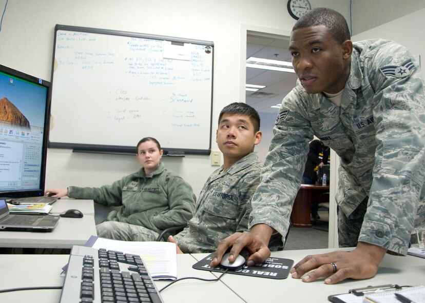 Senior Airman Stephen Yelbert, 436th Comptroller Squadron all things finance specialist, helps Senior Airman Ashley Books and Senior Airman Francis Nguyen, 436th Aerial Port Squadron travel management office, with filing return deployment vouchers Jan. 22, 2014, at the 436th APS,  on Dover Air Force Base, Del.  Yelbert is part of an Air Force pilot program Dover AFB is testing that embeds a finance Airman with a large squadron to assist financial issues such as travel vouchers, government travel card issues and monthly pay discrepancies. (U.S. Air Force photo/Senior Airman Jared Duhon)