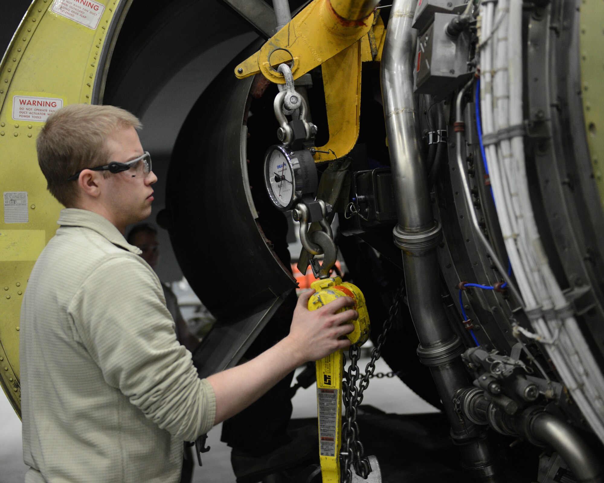U.S. Air Force Airman 1st Class Cody Evans, 100th Maintenance Squadron aerospace propulsion journeyman from Crosby, Texas, monitors the amount of weight on a rigging system while lowering the engine of a KC-135 Stratotanker Jan. 24, 2014, on RAF Mildenhall, England. Raising and lowering aircraft engines is one of the most dangerous jobs a maintainer can perform on an aircraft. Maintenance Airmen must move slowly and in unison to prevent hazards while raising or lowering engines, in addition to abiding by other necessary precautions, to ensure their safety and the integrity of the aircraft. (U.S. Air Force photo by Airman 1st Class Preston Webb/Released)