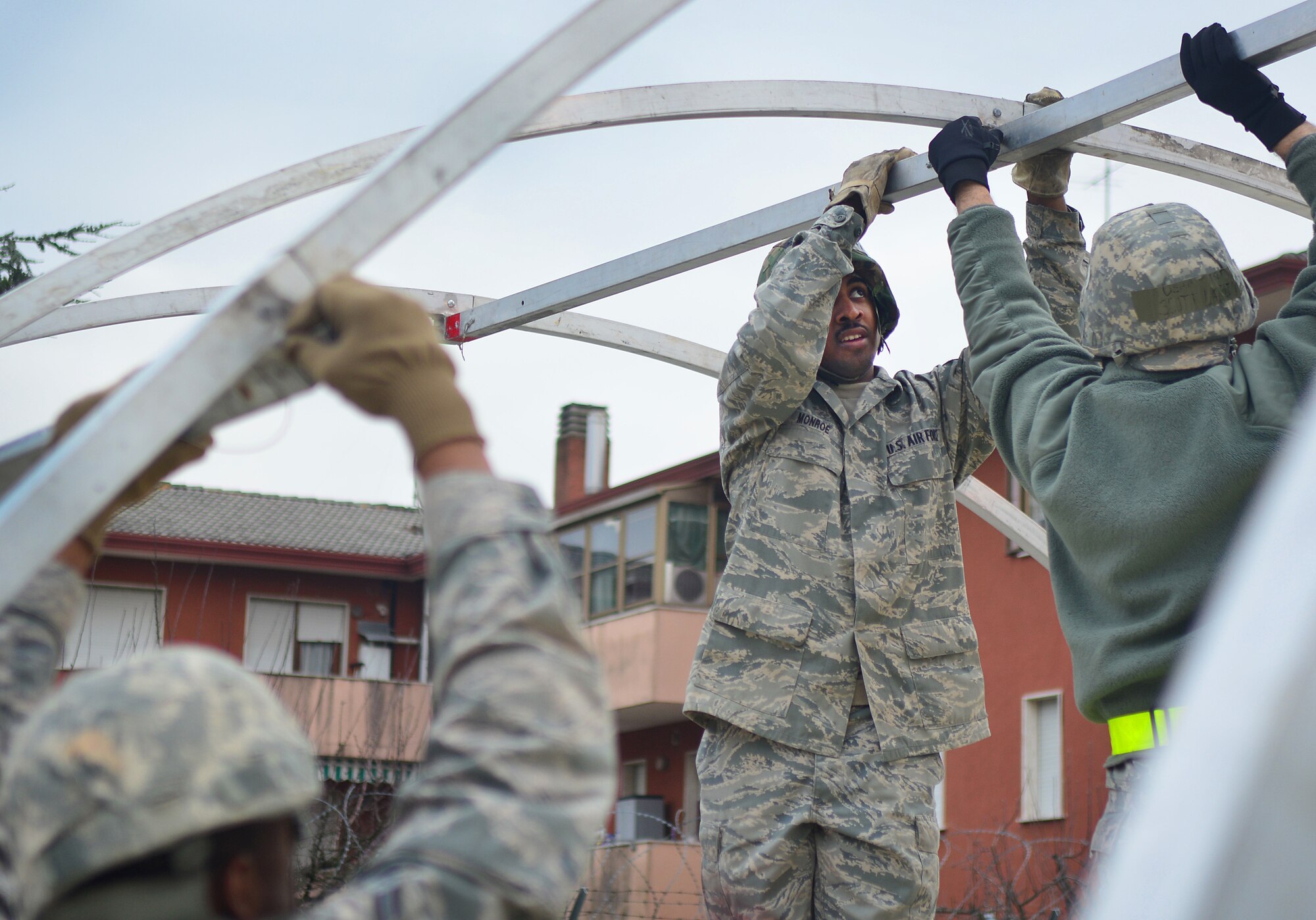 Staff Sgt. Maurice Monroe, 31st Force Support Squadron manpower analyst, helps assemble a tent during an exercise, Jan. 23, 2014, at Aviano Air Base, Italy. More than 100 personnel participated in the exercise from different FSS agencies to include: The dining facility, fitness centers, the Airman and Family Readiness Center and mortuary affairs as well as other small units. (U.S. Air Force photo/Senior Airman Briana Jones)