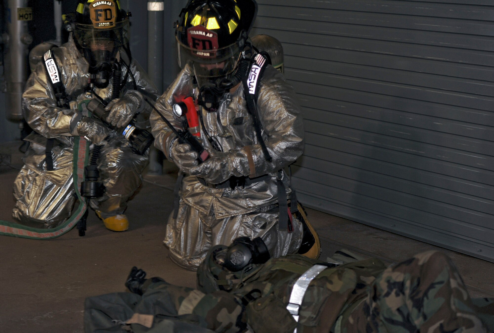 Airman 1st Class Edgar Fernandez and Tech. Sgt. Yubyayny Nicudemus, firefighters with the 35th Civil Engineer Squadron, find a victim while performing a facility search during an operational readiness exercise at Misawa Air Base, Japan, Jan. 27, 2014. During an ORE, units are tested on their combat readiness and ability to execute the mission in a simulated deployed environment. (U.S. Air Force photo/Staff Sgt. Alyssa C. Wallace)