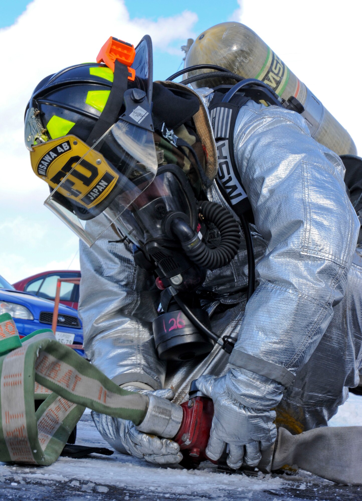 Airman 1st Class Edgar Fernandez, 35th Civil Engineer Squadron firefighter, attaches a hose line to a supply hose in a scenario during Phase II of an operational readiness exercise at Misawa Air Base, Japan, Jan. 27, 2014. As part of the exercise, Fernandez and his team responded to a simulated fire, and were tested on their ability to carry out their mission through simulated attacks. (U.S. Air Force photo/Staff Sgt. Alyssa C. Wallace)