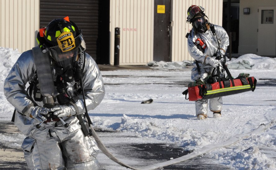 Airman 1st Class Edgar Fernandez, 35th Civil Engineer Squadron, advances a supply line while his teammate, Tech. Sgt. Yubyayny Nicudemus, carries a high-rise hose pack to the scene of a simulated fire during an operational readiness exercise at Misawa Air Base, Japan, Jan. 27, 2014. In real world emergencies, the firefighters use this equipment for interior firefighting in large facilities. (U.S. Air Force photo/Staff Sgt. Alyssa C. Wallace)