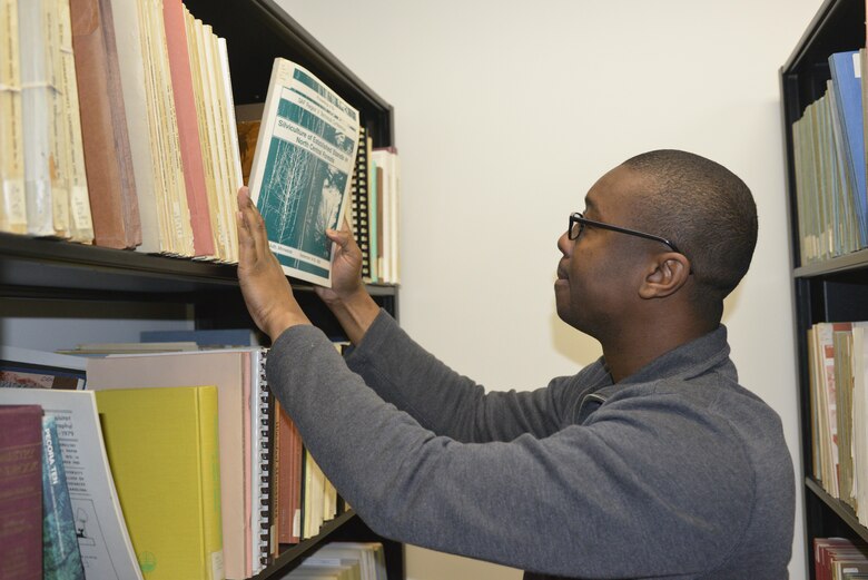 Army Spc. Kurt Phillip from the Operation Warfighter program at Fort Campbel  places books on a shelf in the U.S. Army Corps of Engineers Nashville District libray on Jan. 29, 2013.   Phillip works as a Library assistant and has severe arthritis resulting from multiple operations to his knees which will potentially cause him to be medically discharged.  Operation Warfighter is the first professional transition program active wounded warriors can experience and USACE’s Nashville District is applying it on a group scale. Nashville District partnered with Fort Campbell office where district personnel initiated an active recruiting campaign, interviewing wounded warriors at the base’s WTU for OWF intern positions. (USACE Photo by Mark A. Rankin)  