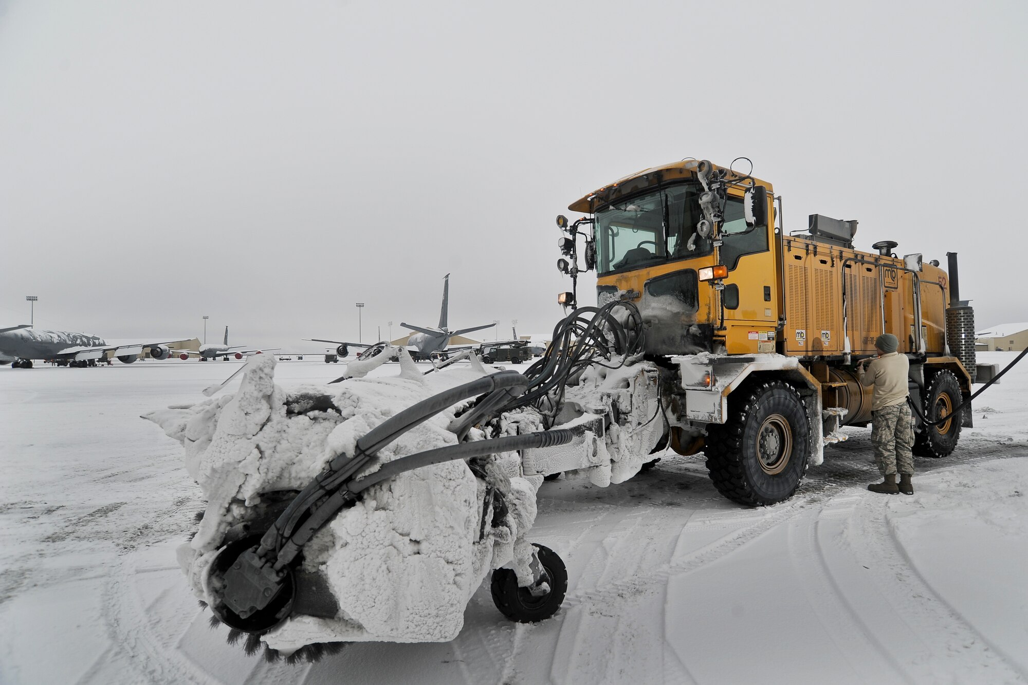 Staff Sgt. Victor Gearhart a 92 Civil Engineer Squadron heavy equipment foreman, refuels a snow removal vehicle to help with flight line clean up for flight preparation at Fairchild Air Force Base, Wash., Jan. 29, 2014. 92nd CE snow barn Airmen work day and night ensuring that aircraft have a safe and visible runway to operate from.  (U.S. Air Force photo by Staff Sgt. Alexandre Montes/ RELEASED)