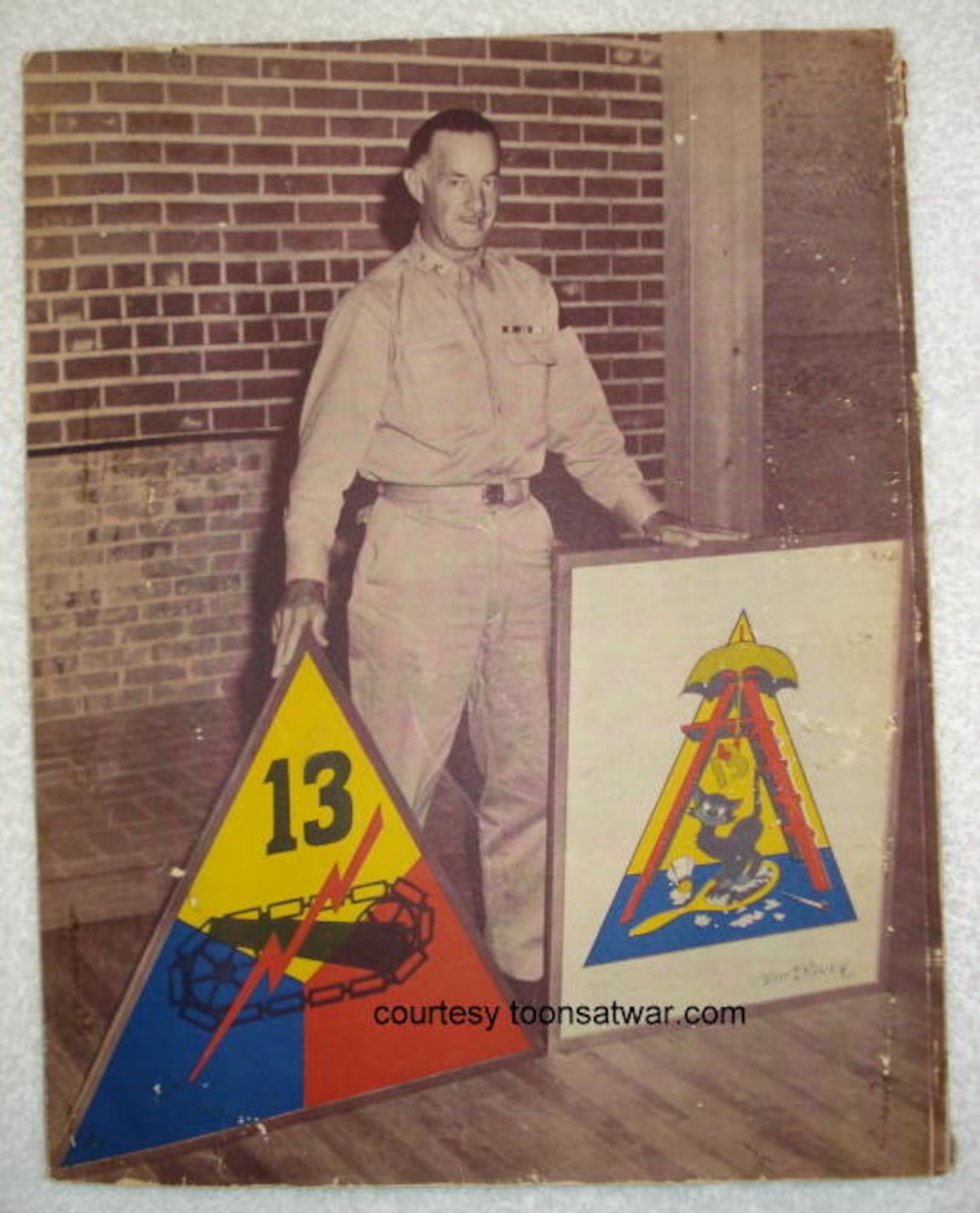 Maj. Gen. John Wogan, the 13th Armored Division commander from Oct., 1942 to April, 1945 stands next to the unit insignias. (Courtesy photo from toonsatwar.com/Released) 