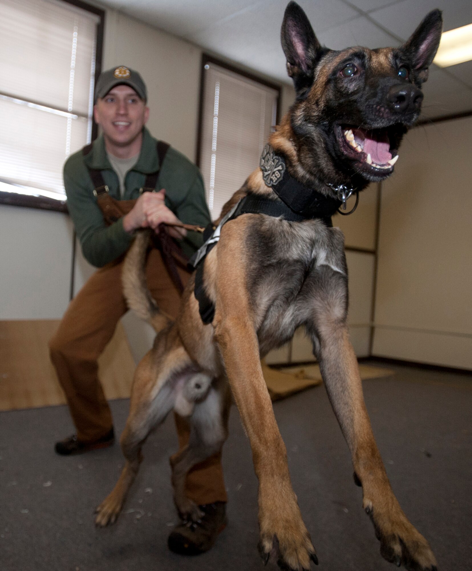 Air Force Staff Sgt. Joe Burns reigns in his excited military working dog after training to recover victims or perpetrators in a building on Joint Base Elmendorf-Richardson, Alaska, Jan. 23, 2014. Burns is a 673d Security Forces Squadron MWD handler from Portland, Maine. (U.S. Air Force photo/Staff Sgt. Robert Barnett)