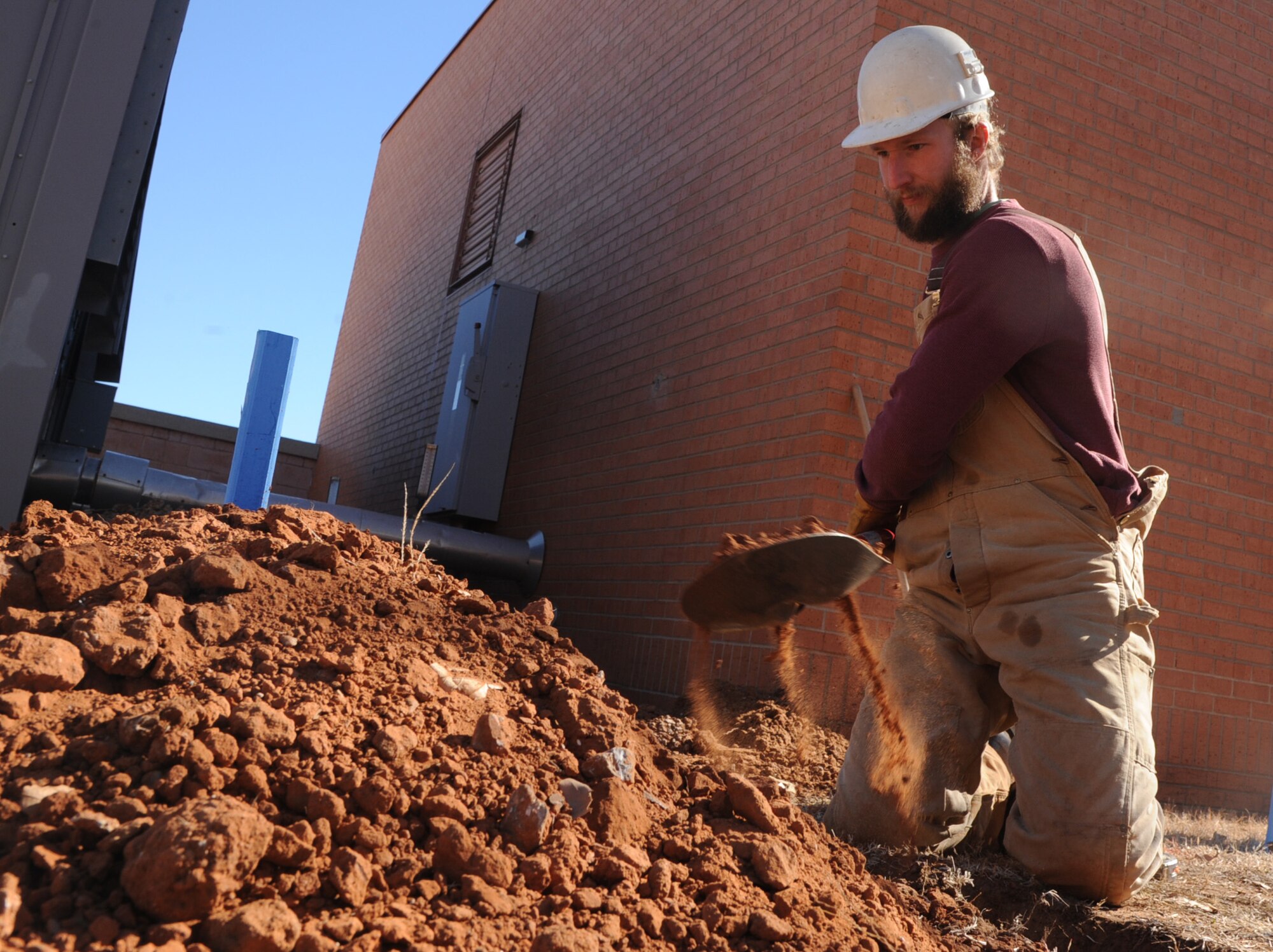 Derek Engle, a PAE laborer, digs a trench in search of water pipes for a project that will upgrade the current heating, ventilation and air conditioning system in the unaccompanied officers’ quarters. The $2 million project, which began earlier this month, is scheduled for completion this August. (U.S. Air Force photo/ Senior Airman Frank Casciotta)