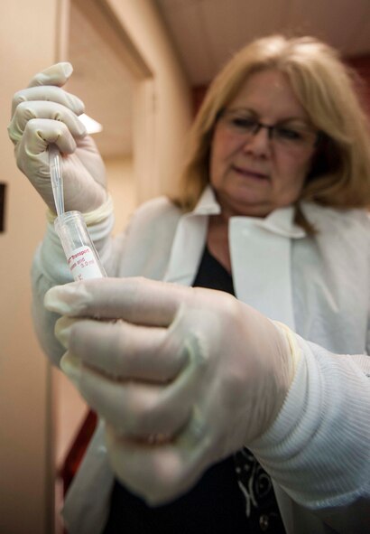 Lavon Slind, 5th Medical Group laboratory technical supervisor, extracts a sample using a pipet to test for Influenza A and B in the laboratory at Minot Air Force Base, N.D., Jan. 23, 2014. Slind works alongside a team of Airmen and civilians who test everything from blood samples to throat swabs. (U.S. Air Force photo/Senior Airman Stephanie Sauberan)