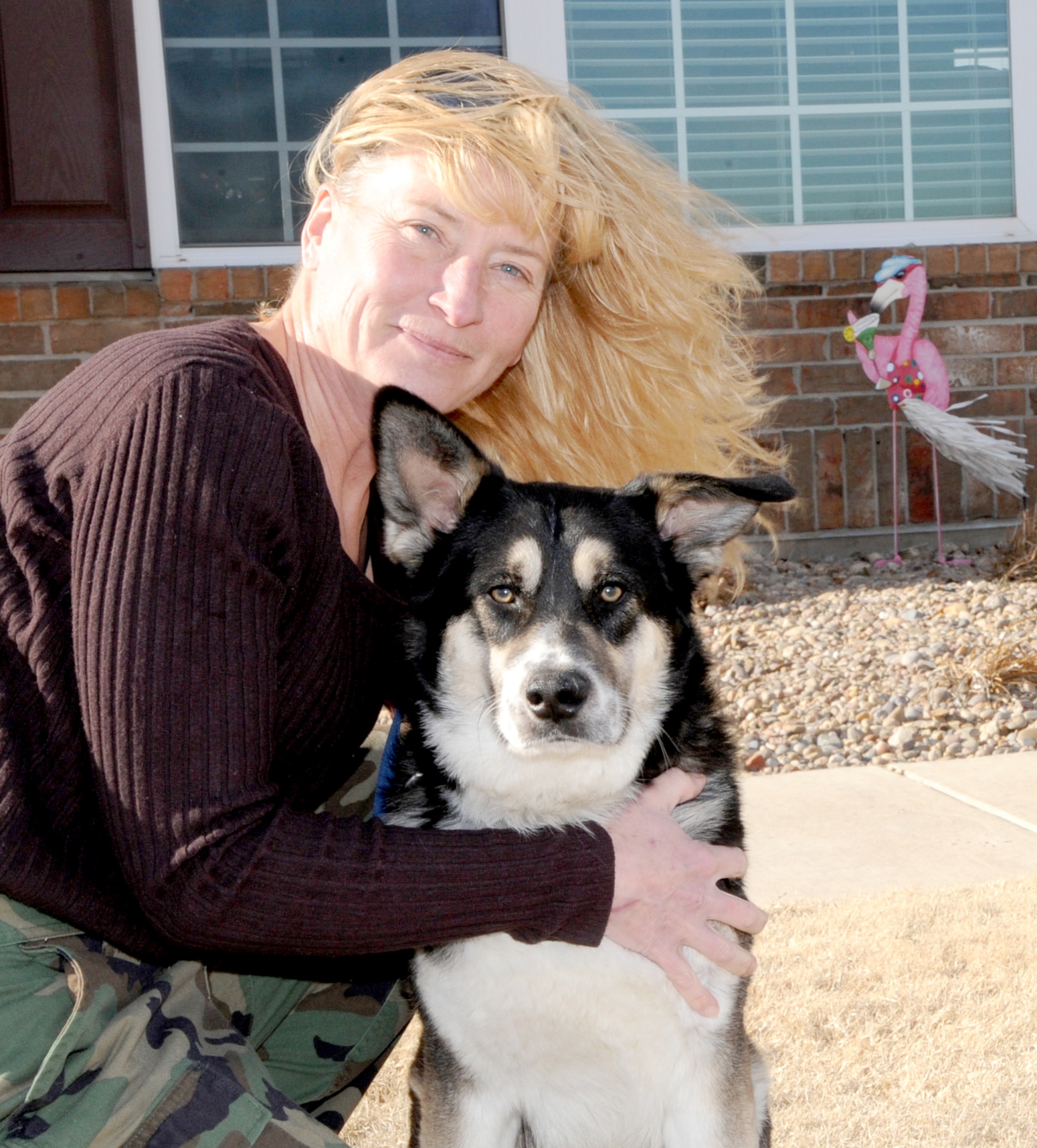 Clarence the “gate dog” has a forever home thanks to Julie Abatti, (pictured here with Clarence), and her husband, Col. James Abatti, the 71st Operations Group commander at Vance Air Force Base, Okla. (U.S. Air Force photo/ Senior Airman Frank Casciotta)