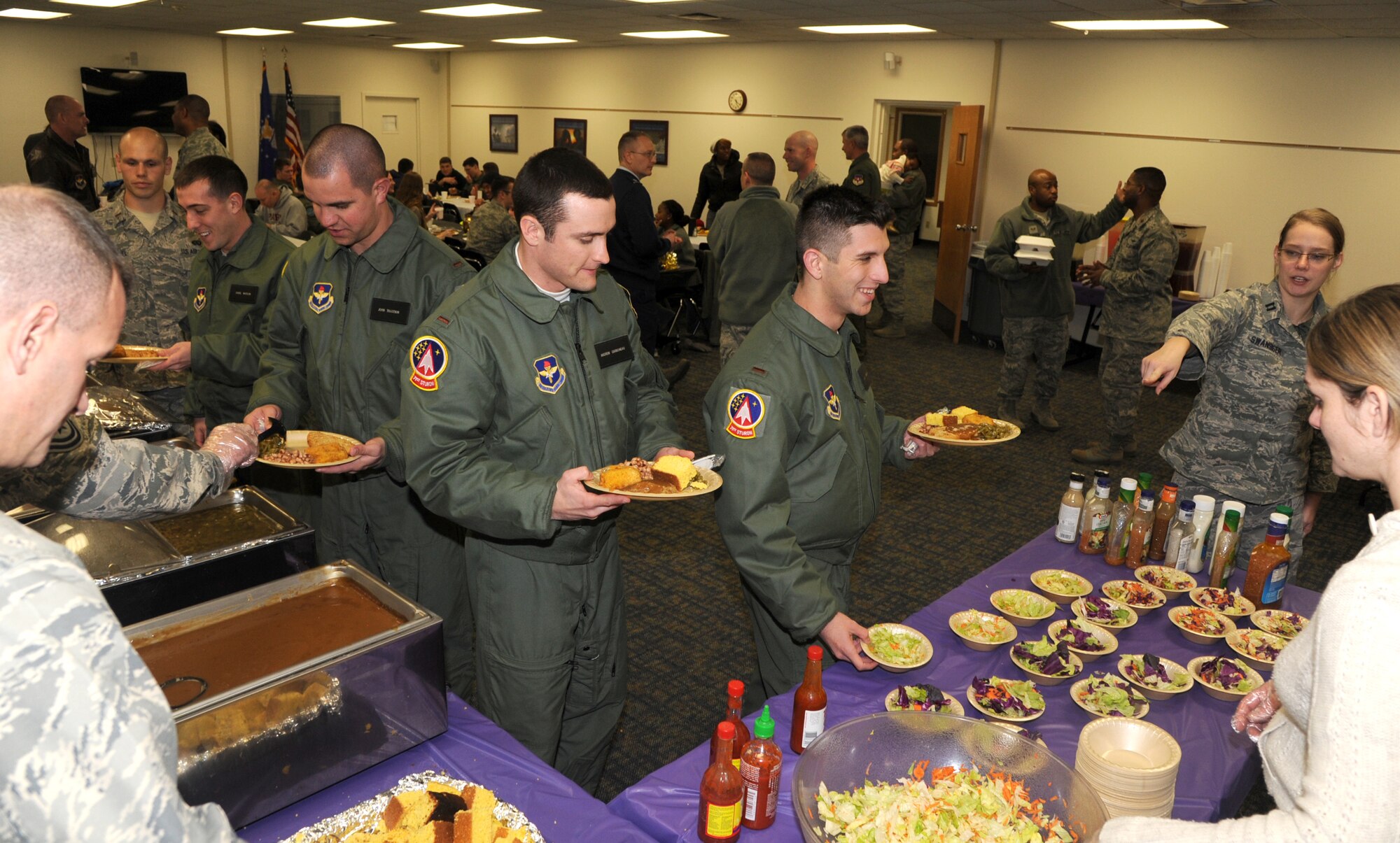 Attendees are served dinner during the Singles’ International Gourmet Meal Opportunity Jan. 27 in the Community Chapel Activity Center at Vance Air Force Base, Okla. Twenty volunteers from the 71st Mission Support Group served 168 meals. (U.S. Air Force photo/ Senior Airman Frank Casciotta)