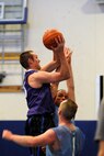Tom Fow, 4th Space Operations Squadron, shoots over defenders during the first half of a Schriever intramural basketball league game against the Space Innovation and Development Squadron. The SIDC team, which represents the U.S. Air Force Warfare Center, pulled out a 60-41 victory to maintain its hold on second place in the league standings. (U.S. Air Force photo/Dennis Rogers) 