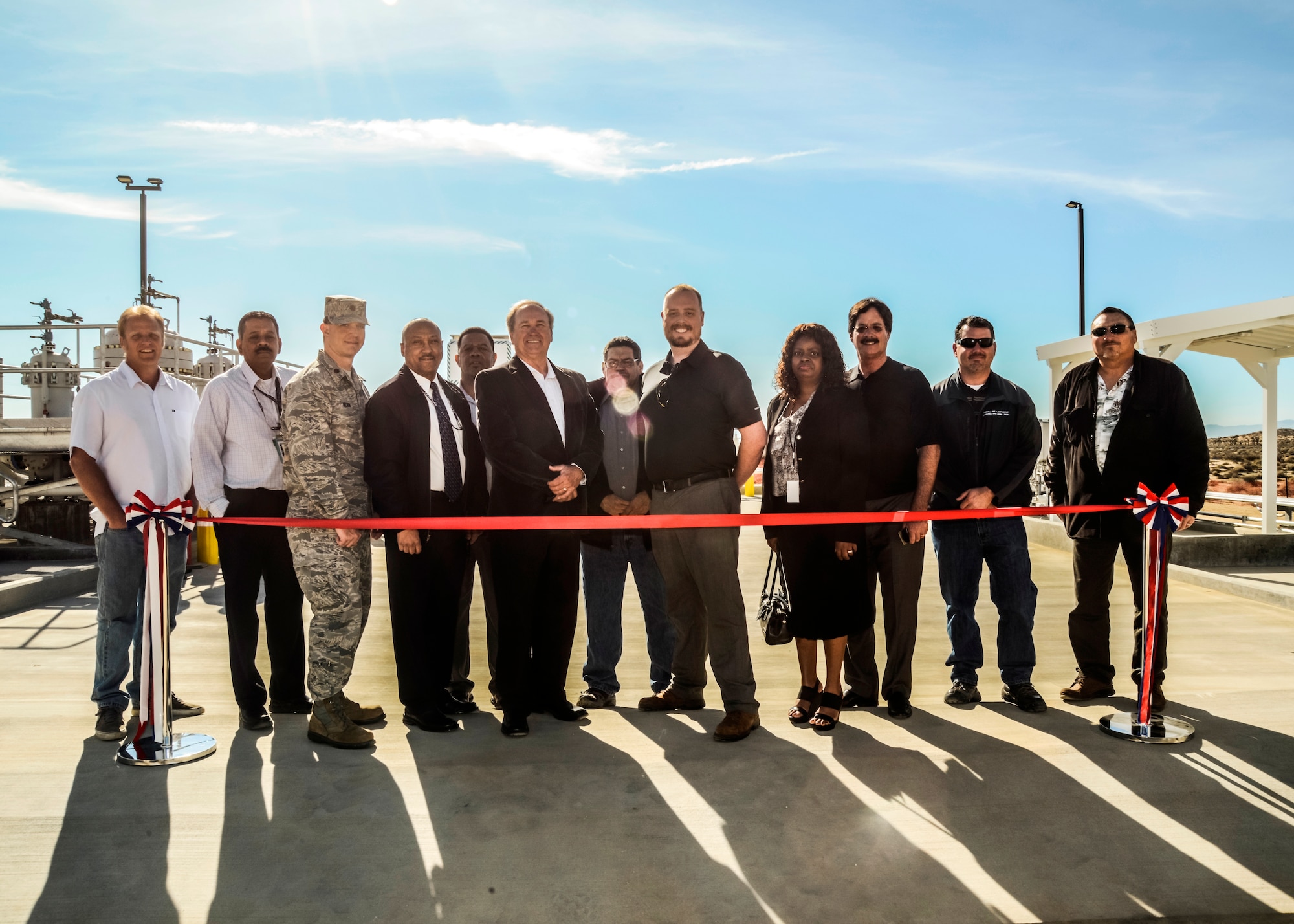Members from the 412th Civil Engineering Division, 412th Communications Squadron, Kinder Morgan Energy Partners and the Defense Logistics Agency, gather to cut the ceremonial ribbon to officially open up the Kinder Morgan Metering Station Facility Jan. 22. The new system eliminates Edwards AFB’s dependency on three jet fuel break-out storage tanks located at the old George Air Force Base in Victorville, Calif. Beforehand, jet fuel was piped from the San Pedro Port to the George AFB tanks. There, three military fuel additives were injected into the jet fuel and then the fuel was transferred through a filtration system to Edwards AFB via a 57-mile, 6-inch fuel pipeline. (U.S. Air Force photo by Kenji Thuloweit)