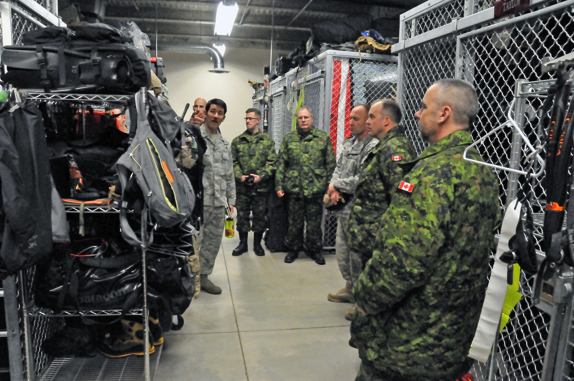 JOINT BASE ELMENDORF-RICHARDSON, Alaska— Major Matthew Komatsu (left), 212th Rescue Squadron director of operations, shows the attendees of an Arctic General Officer/Flag Officer Conference the types of equipment Air Force Pararescuemen use in search and rescue efforts Jan. 10. Alaskan Command/Joint Task Force-Alaska and U.S. Army Alaska hosted a GO/FO Conference Jan. 7-11, which included distinguished guests from the U.S. Air Force, U.S. Army, Alaska National Guard, U.S. Coast Guard and Canadian Forces, to strengthen partnerships, discuss future Arctic challenges and joint capabilities. (U.S. Air Force photo/Tech. Sgt. John Gordinier)