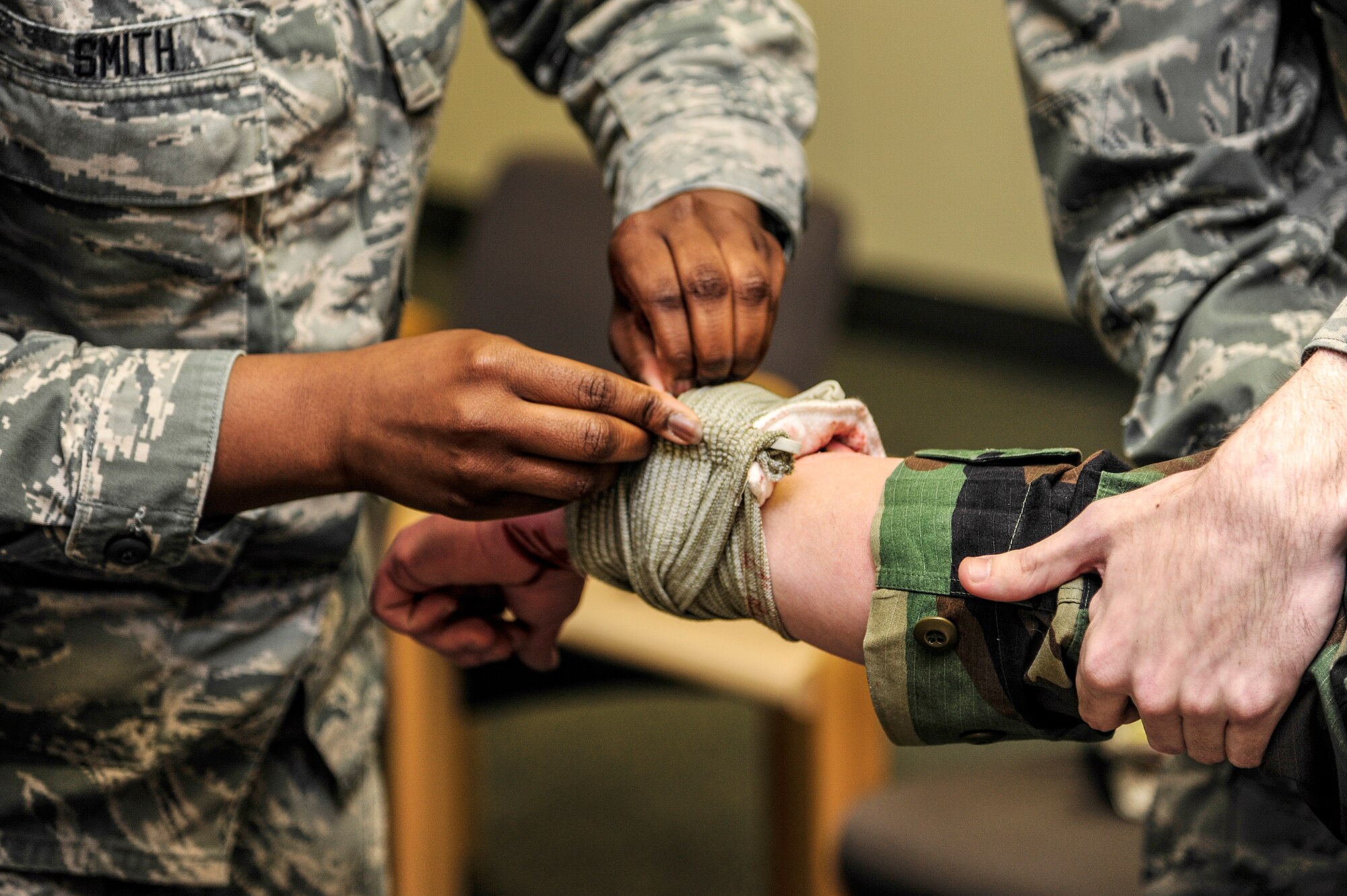 Airman 1st Class Celeste Smith, 354th Comptroller Squadron financial services technician, wraps a simulated wound of an injured individual during a Self-Aid Buddy Care scenario Jan. 28, 2014, Eielson Air Force Base, Alaska. SABC scenarios are frequently used during Operational Readiness Exercises to test Airmen’s reaction and response. (U.S. Air Force photo by Senior Airman Zachary Perras/Released)