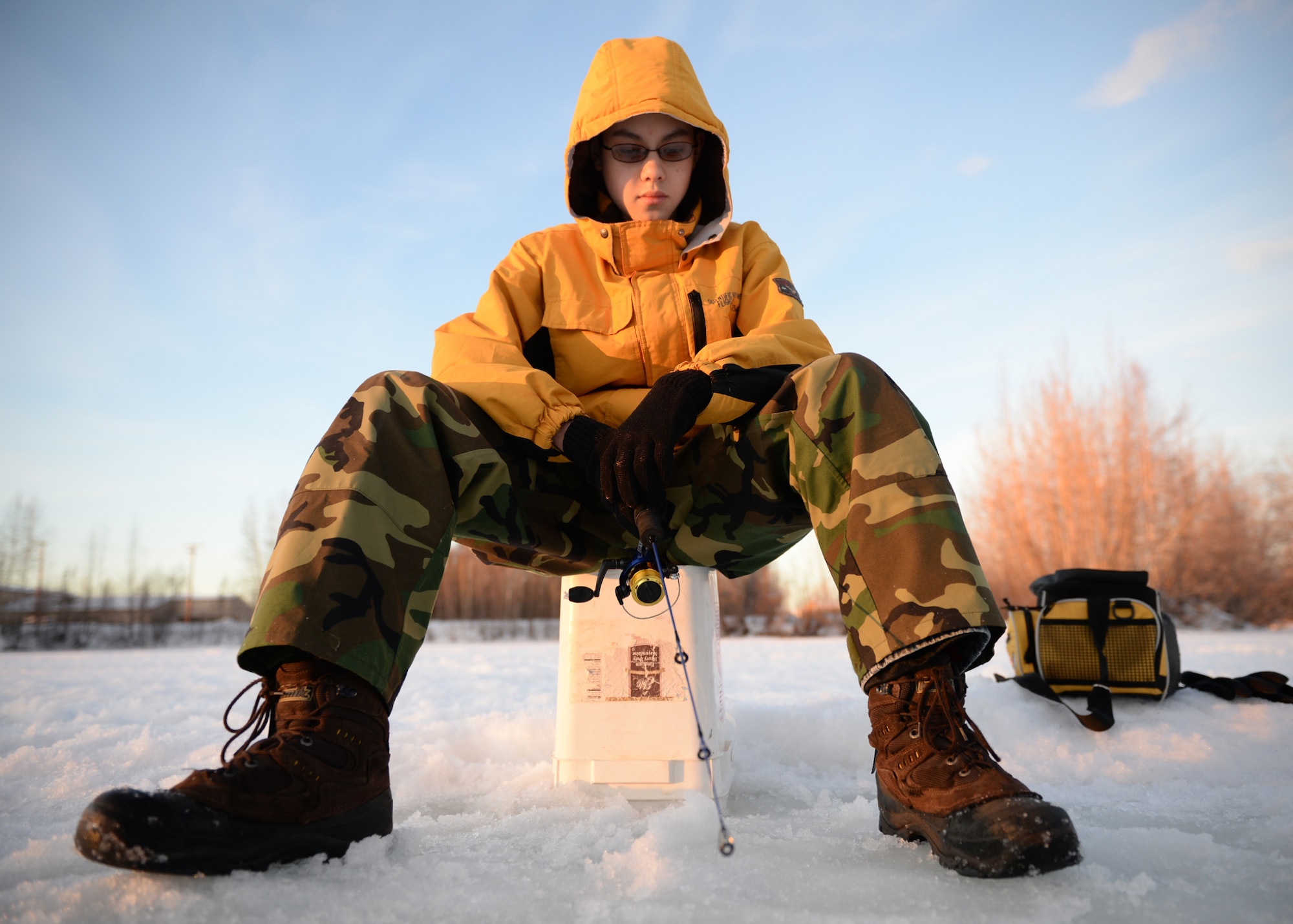 Christopher, son of Lt. Col. Edward Liberman, fishes for trout during an ice fishing day at Moose Lake, Eielson Air Force Base, Alaska, Jan. 25, 2014. Families were encouraged to get out on the ice and enjoy unseasonably warm weather while promoting resiliency through outdoor activities. (U.S. Air Force photo by Senior Airman Shawn Nickel)