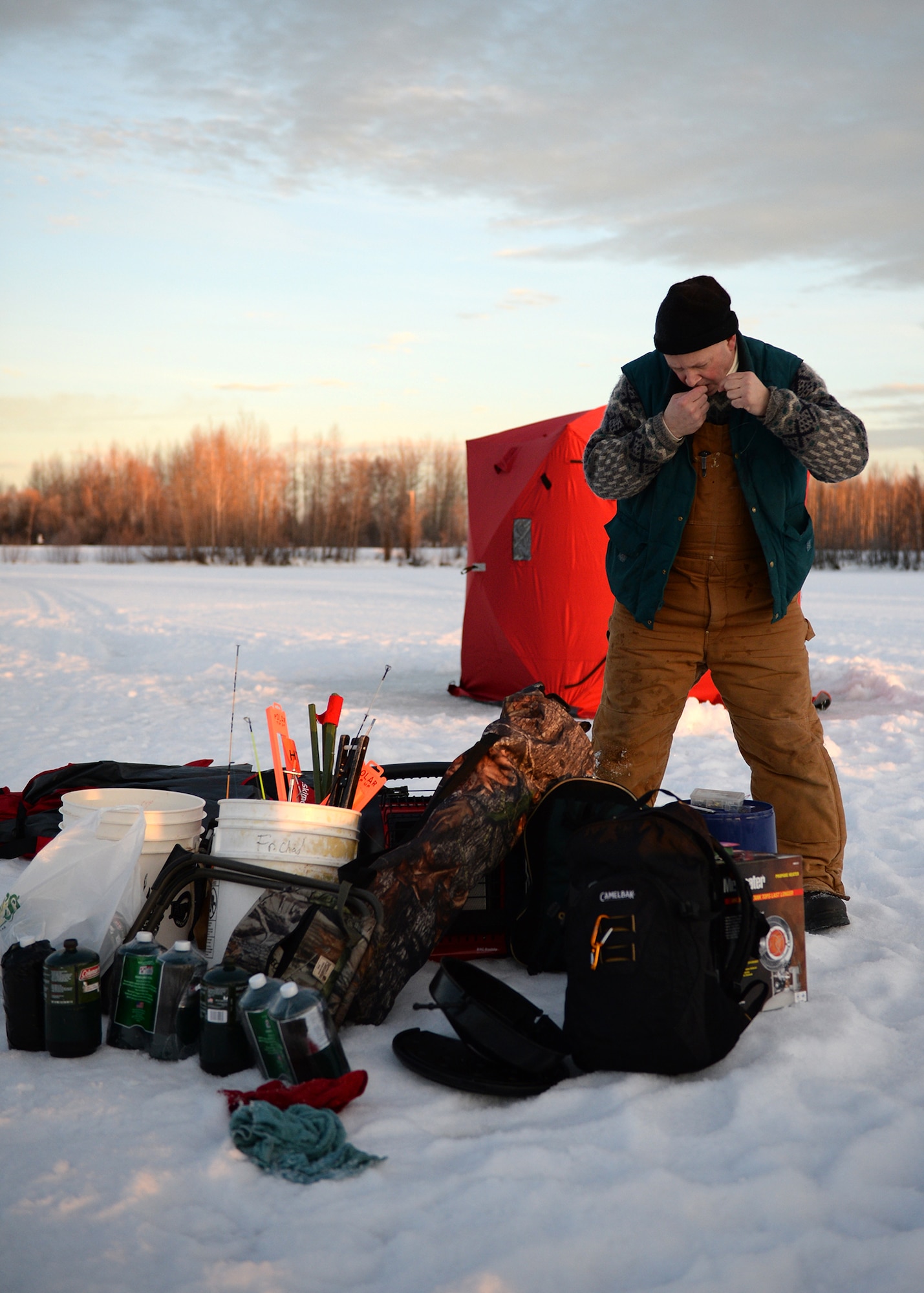 Ch. (Maj.) Chad Zielinski, 354th Fighter Wing Catholic chaplain, sets up a line with a fishing hook during an ice fishing day at Moose Lake, Eielson Air Force Base, Alaska, Jan. 25, 2014. The day helped build resiliency by promoting outdoor activities. (U.S. Air Force photo by Senior Airman Shawn Nickel)