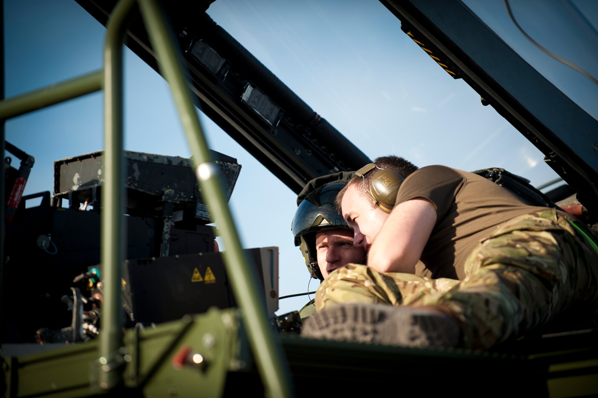 Royal Air Force Senior Air Craftsman Glen Lown, IX Bomber Squadron aircraft maintenance mechanic, from RAF Marham, United Kingdom, discusses an aircraft discrepancy with a pilot following a training mission Jan. 28, 2014, at Nellis Air Force Base, Nev. Coalition aircraft maintainers support flying operations being carried out by pilots during the Red Flag exercise. (U.S. Air Force photo by Airman 1st Class Joshua Kleinholz)