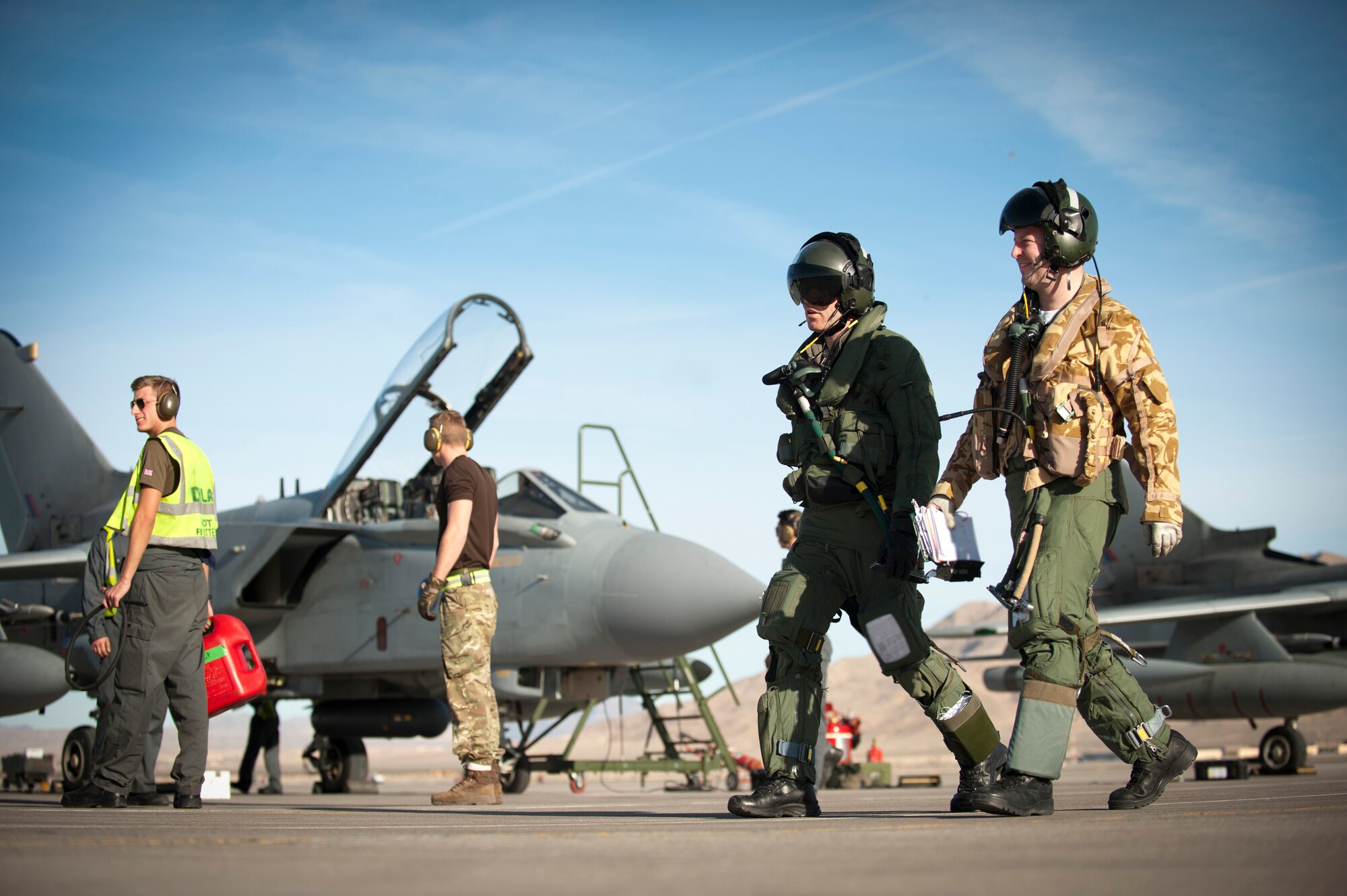 Royal Air Force Flight Lt. Richard Woods (right), and Squadron Leader David Bouldon, (left), IX Bomber Squadron GR4 Tornado pilots from RAF Marham, United Kingdom, step away from their aircraft for a debrief following a training mission Jan. 28, 2014, at Nellis Air Force Base, Nev. Coalition service members from the UK and Australia made the trip from their respective countries to participate in the Air Force’s premier air combat exercise, Red Flag. (U.S. Air Force photo by Airman 1st class Joshua Kleinholz)