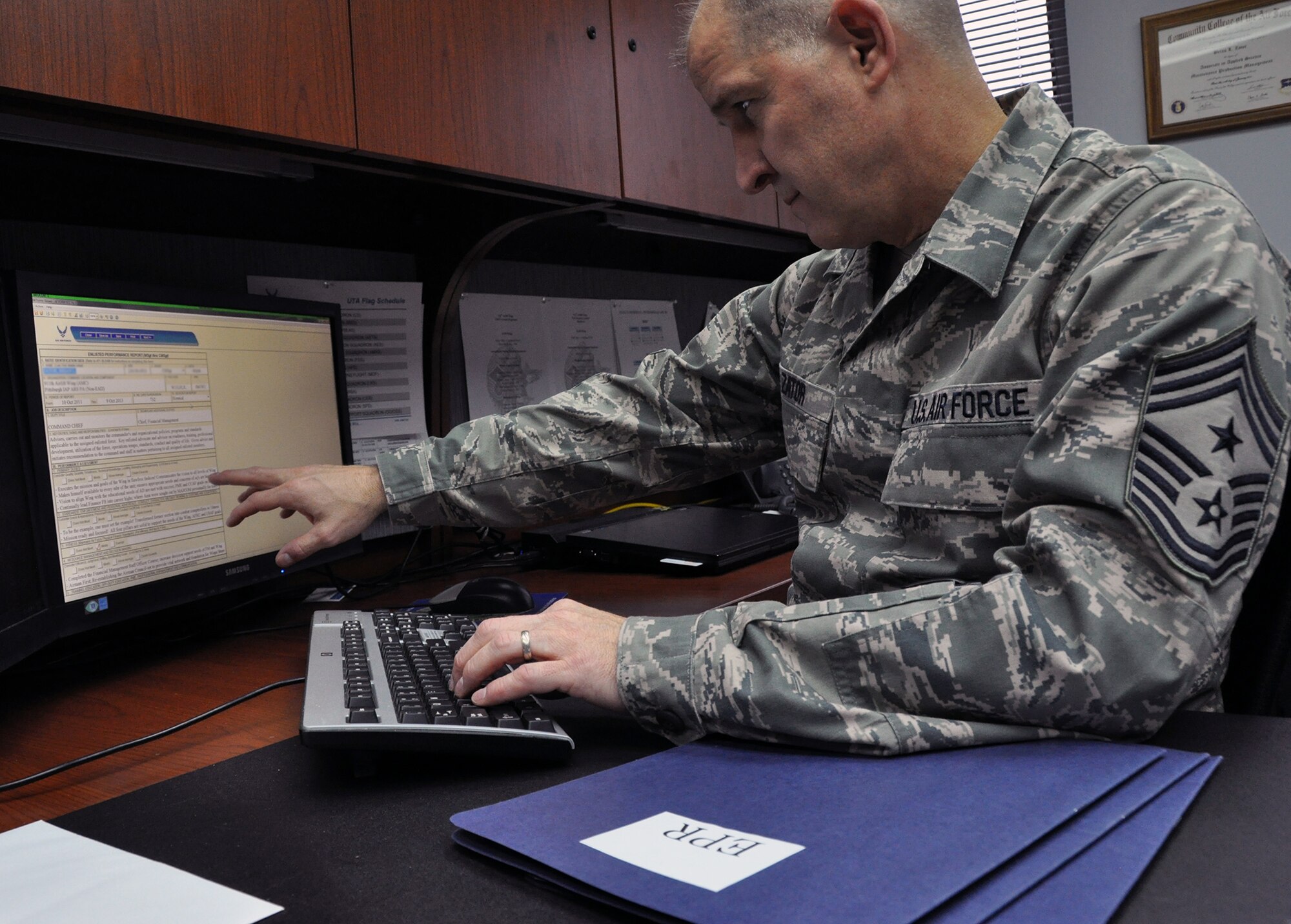 Command Chief Master Sgt. Brian L. Zator, reviews an Enlisted Performance Report of an Airman under his leadership at the Pittsburgh International Airport Air Reserve Station, Jan. 12, 2014.  As of Jan. 1, 2014, an additional category has been added to the EPR to reflect how an Airman contributes to fostering a healthy organizational environment. (U.S. Air Force photo by Senior Airman Joseph E. Bridge)