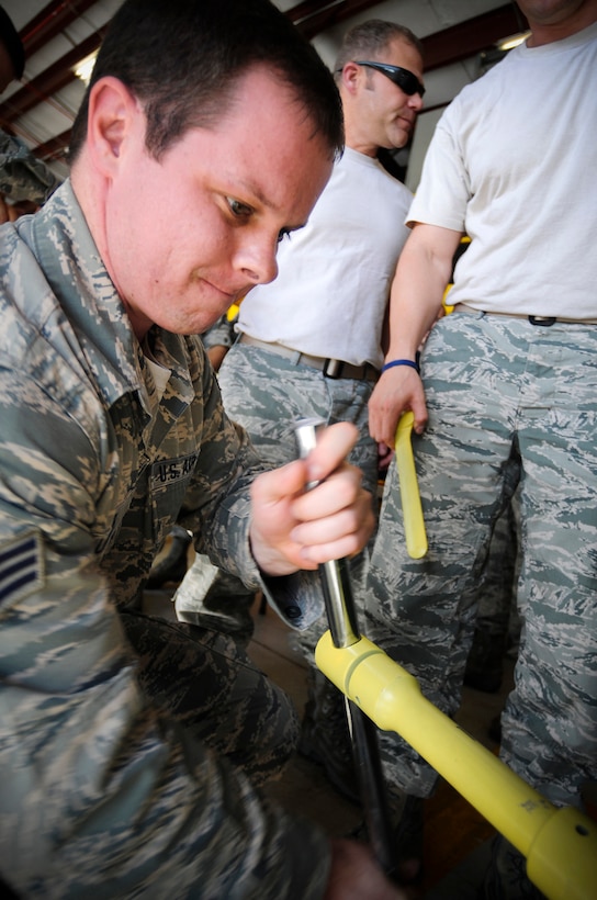 U.S. Air Force Senior Amn. Joshua Linder, Fire Rescue with the 125th Fighter Wing Civil Engineering Flight, patches a simulated leaking 1-ton chlorine cylinder as part of 'Valiant Eagle', a compliance competition within the 125th Fighter Wing at Jacksonville International Airport, Jacksonville Fla. Dec 4, 2013..