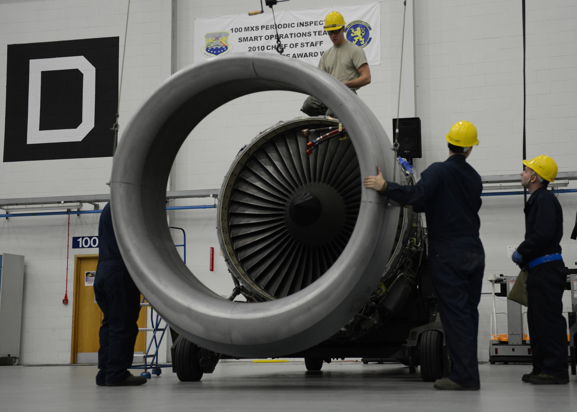 Team Mildenhall maintainers assemble the final components of a KC-135 Stratotanker engine Jan. 24, 2014, on RAF Mildenhall, England. To move some of the larger parts from one engine to the other, Airmen used a ceiling-mounted crane. Maintenance Airmen take every precaution, and move slowly and in unison, to prevent hazards while operating the crane. (U.S. Air Force photo by Airman 1st Class Preston Webb/Released)