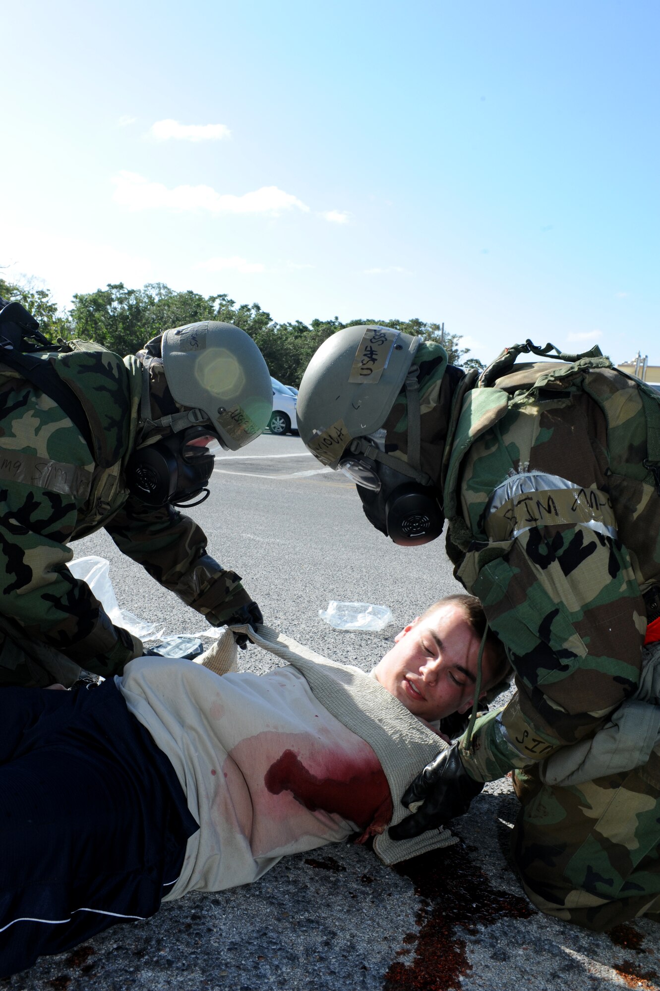 U.S. Air Force Staff Sgts. Jessica Calkins and Eric Viola, 18th Comptroller Squadron budget analyst and customer service member, perform self-aid and buddy care on a simulated victim during a Mission Focused Exercise on Kadena Air Base, Japan, Jan. 29, 2014. MFEs give Airmen the opportunity to train in a safe environment and prepare for real world contingencies. (U.S. Air Force photo by Airman 1st Class Hailey R. Staker)