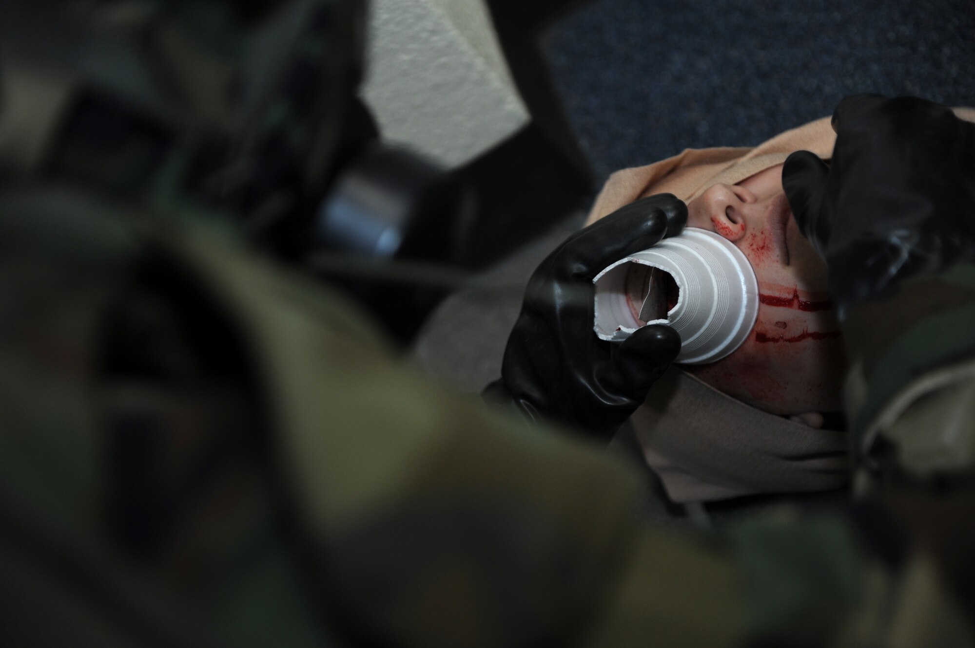 A U.S. Air Force Airman places a styrofoam cup over a simulated eye wound to help stabilize the shrapnel during a Mission Focused Exercise on Kadena Air Base, Japan, Jan. 29, 2014. MFEs are designed to test Airmen on a variety of survive and operate scenarios such as self-aid and buddy care, in which Airmen are tasked to perform basic medical techniques while waiting for medical personnel to arrive on scene. (U.S. Air Force photo by Airman 1st Class Hailey R. Staker) 