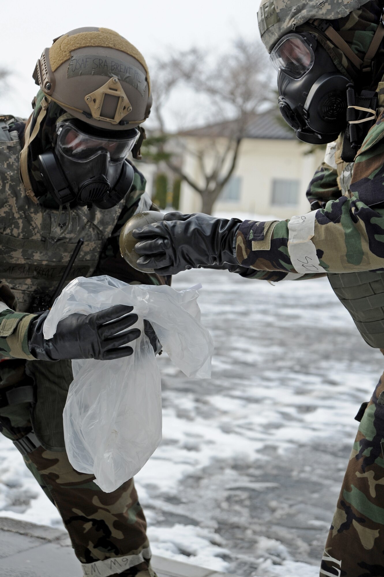 U.S. Air Force Senior Airman Brent Points and Airman 1st Class Anthony Donelan, 35th Civil Engineer Squadron Explosive Ordnance Disposal technicians, place unexploded ordnance into a bag preventing further contamination to an affected area. The EOD team takes the time to inspect each UXO prior to removing it from it's original position. (U.S. Air Force photo/Tech. Sgt. April Quintanilla)