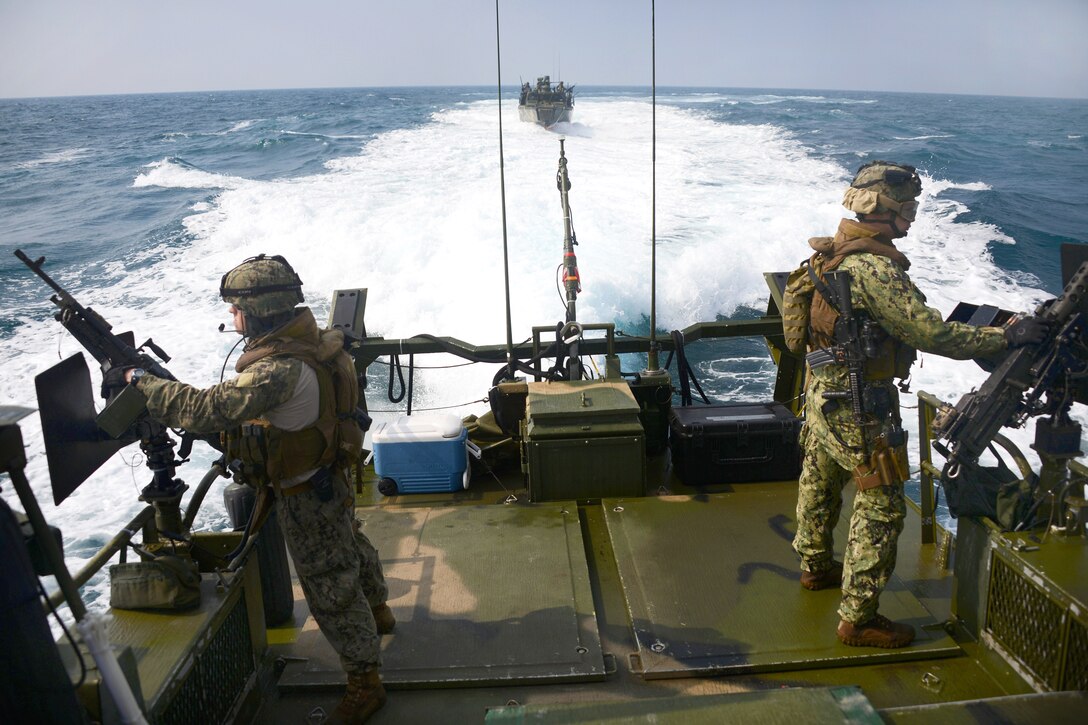 U.S. Navy Petty Officers 3rd Class Jose Romo, left, and Chase Grote man weapons aboard a riverine command boat during a training exercise in the Arabian Gulf, Jan. 21, 2014. Romo and Grote are enginemen assigned to Task Group 56.7.4.