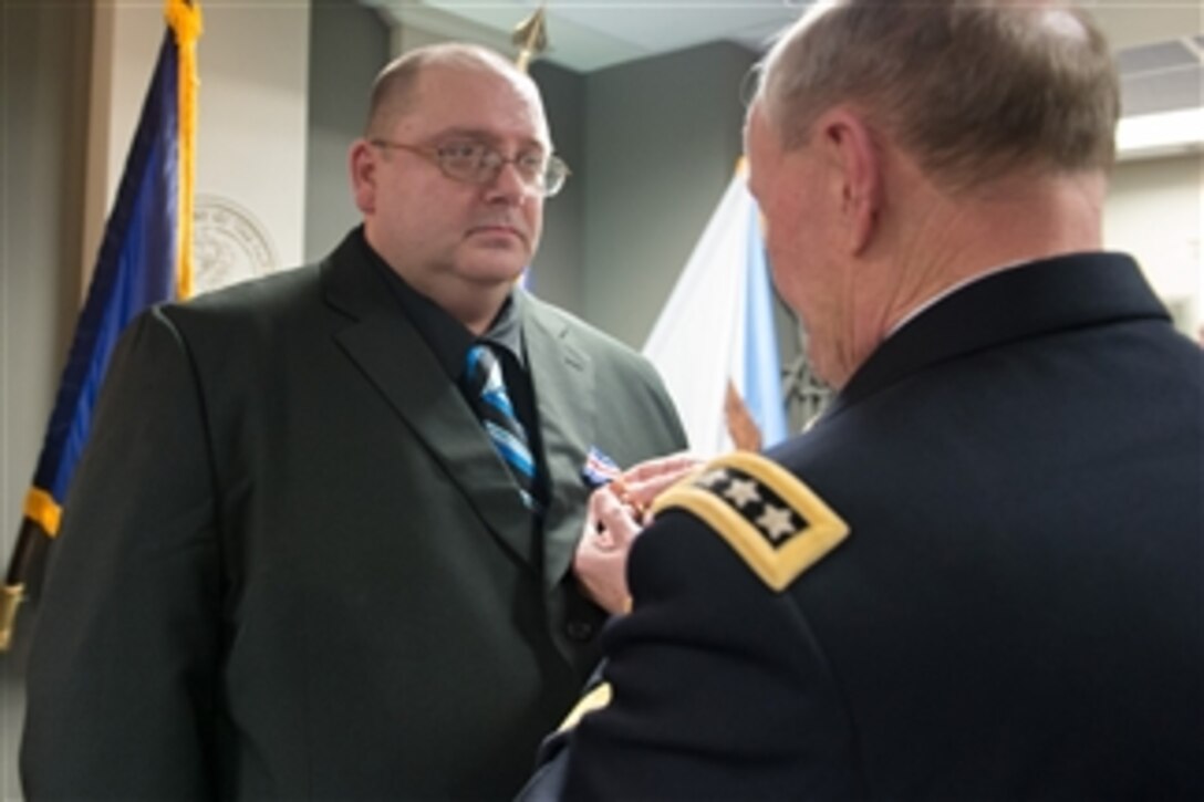 Army Gen. Martin E. Dempsey, chairman of the Joint Chiefs of Staff, presents retired Army Pfc. Mark A. Deville with a Silver Star, the nation's third highest military award, for his actions in Korea 30 years ago, at the Pentagon, Jan. 28, 2014.