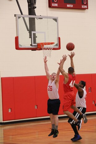 Cpl. Philip Jimenez, player for Officer Candidate School intramural basketball team, attempts to block a player from Marine Helicopter Squadron One during the HMX-1 versus Officer Candidate School game at Barber Physical Activity Center on Jan. 22, 2014. HMX-1 won with a score of 41 to 34.