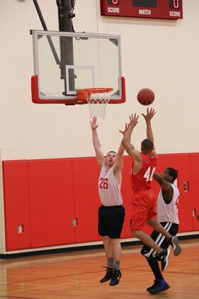 Cpl. Philip Jimenez, player for Officer Candidate School intramural basketball team, attempts to block a player from Marine Helicopter Squadron One during the HMX-1 versus Officer Candidate School game at Barber Physical Activity Center on Jan. 22, 2014. HMX-1 won with a score of 41 to 34.