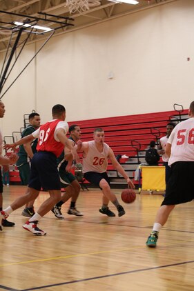Cpl. Philip Jimenez, player for Officer Candidate School intramural basketball team, dribbles the ball during the OCS versus Marine Helicopter Squadron One game at Barber Physical Activity Center on Jan. 22, 2014. HMX-1 won with a score of 41 to 34.