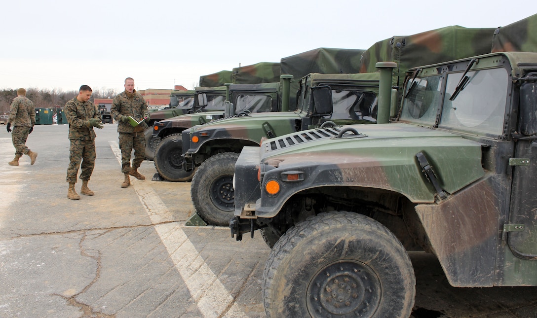 Marines with Motor Transportation Operations, The Basic School, inspect a row of Humvees on Jan. 29, 2014, aboard Marine Corps Base Quantico. Marines in motor transportation are responsible for delivering people, water, ammunition and all other resources to the front lines. The Department of Defense aims to become more sustainable through alternative energy methods that will reduce risk to forces delivering those resources.