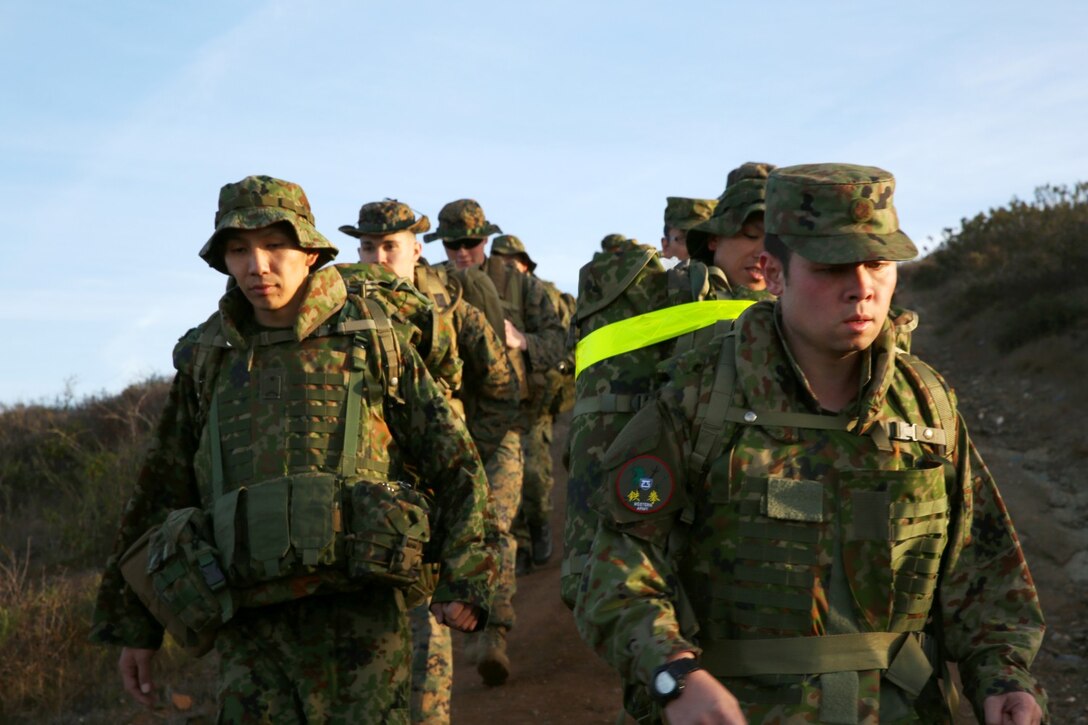 U.S. Marines with 1st Air Naval Gunfire Liaison Company and soldiers from the Japan Ground Self-Defense Force stand at the half-way point of a hike during Exercise Iron Fist 2014 aboard Camp Pendleton, Calif., Jan. 28, 2014. Iron Fist 2014 is an amphibious exercise that brings together Marines and sailors from the 15th Marine Expeditionary Unit, other I Marine Expeditionary Force units, and soldiers from the JGSDF, to promote military interoperability and hone individual and small-unit skills through challenging, complex and realistic training. (U.S. Marine Corps photo by Lance Cpl. Anna K. Albrecht/Released)
