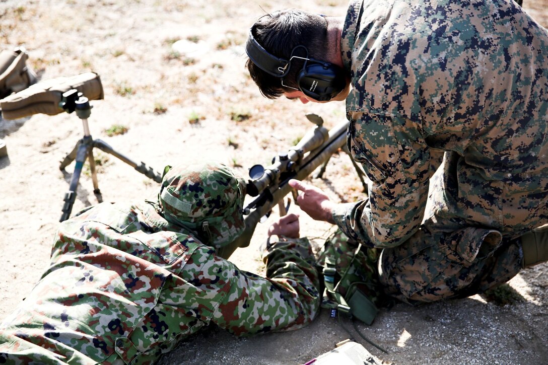 A U.S. Marine, right, pre-scout sniper instructor, 1st Marine Division Schools, clears the weapon of a soldier from the Japan Ground Self-Defense Force after a shooting drill during Exercise Iron Fist 2014 aboard Camp Pendleton, Calif., Jan. 29, 2014. Iron Fist is an amphibious exercise that brings together Marines and sailors from the 15th Marine Expeditionary Unit, other I Marine Expeditionary Force units, and soldiers from the JGSDF, to promote military interoperability and hone individual and small-unit skills through challenging, complex and realistic training. (U.S. Marine Corps photo by Lance Cpl. Ricardo Hurtado/Released)