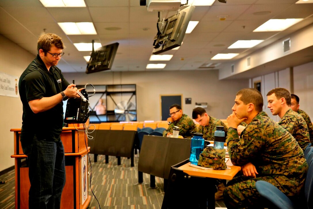 Mike Budnicki, engineer with Remote Diagnostic Technologies, from Philadelphia, Pa. talks to Marines and Sailors about the Tempus Pro, a tactical telemedicine device, over two days of informational and operational testing aboard Camp Pendleton, Calif., Jan. 22-23. The Tempus Pro attaches to the patient and broadcasts their vital signs back to a battalion aid station or aiding physician so that they can instruct and help the corpsman.