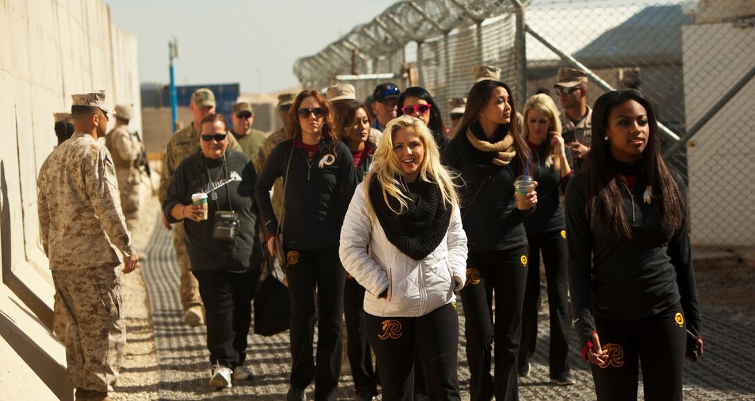 Several Washington Redskins cheerleaders made a trip to support and visit the troops aboard Camp Leatherneck, Afghanistan, Jan. 28, 2014. To show their appreciation for those serving in support of Operation Enduring Freedom, they personally autographed several calendars starring the cheerleaders and posed for photographs with service members. (U.S. Marine Corps photo by Cpl. Cody Haas/ released)