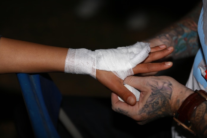 Sergeant Misha Nassiri, an ammunition technician with Headquarters Battalion, 1st Marine Division, wraps her hands before her first mixed martial arts match held at Valley Center, Calif., Jan. 18, 2014. Nassiri, a native of San Diego, won the match by technical knockout in the first 20 seconds of round one. (U.S. Marine Corps photo by Lance Cpl. Jonathan Boynes/released)

Read more: http://www.dvidshub.net/image/1155834/female-marine-enters-pro-mma-with-20-second-knockout#.Uurk5vldXng#ixzz2rveBsgx2