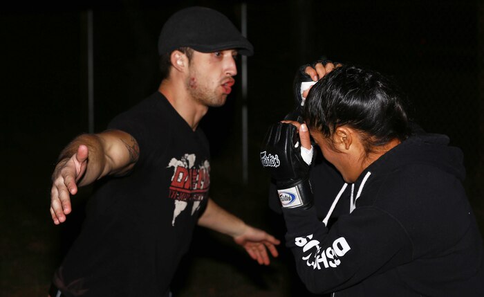 Sergeant Misha Nassiri, an ammunition technician with Headquarters Battalion, 1st Marine Division, spars with one of her trainers before her first professional mixed martial arts match held at Valley Center, Calif., Jan. 18, 2014. Nassiri, a native of San Diego, won the match by technical knockout in the first 20 seconds of round one. (U.S. Marine Corps photo by Lance Cpl. Jonathan Boynes/released)