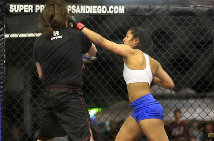 Sergeant Misha Nassiri, an ammunition technician with Headquarters Battalion, 1st Marine Division, strikes her opponent during her first professional mixed martial arts match held at Valley Center, Calif., Jan. 18, 2014. Nassiri, a native of San Diego, won the match by technical knockout in the first 20 seconds of round one. (U.S. Marine Corps photo by Lance Cpl. Jonathan Boynes/released)