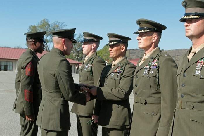 Colonel Jason Q. Bohm, 5th Marine Regiment commanding officer, delivers a bundle of French Fourragères to Lt. Col. Kevin W. Matthews, commanding officer, 1st Battalion, 5th Marines, during a ceremony at Marine Corps Base Camp Pendleton, Calif., Jan. 22, 2014. The battalion commanders presented the prestigious fourragère, a green braided cord, to their newest Marines to wear on their left shoulders in uniform. The 5th Marine Regiment was authorized to wear the fourragère by the French government after demonstrating valor in combat in at least three battles during World War I for which the regiment was awarded the Croix de Guerre. The transfer of the award from the commander through his subordinate leaders symbolized the acceptance of the new Marine into the unit by each member of the chain of command. 5th Marines is the most decorated infantry regiment in the Marine Corps and one of the most battle-tested units in the armed services, having fought in fierce battles during World War I, World War II, Korea, Vietnam, Iraq and Afghanistan. Currently, the regiment provides combat-ready ground forces for deployment worldwide and on U.S. Navy ships in the Pacific and southwest Asia as part of Marine Expeditionary Units.
 (U.S. Marine Corps photo by Sgt. Jacob H. Harrer / released)
