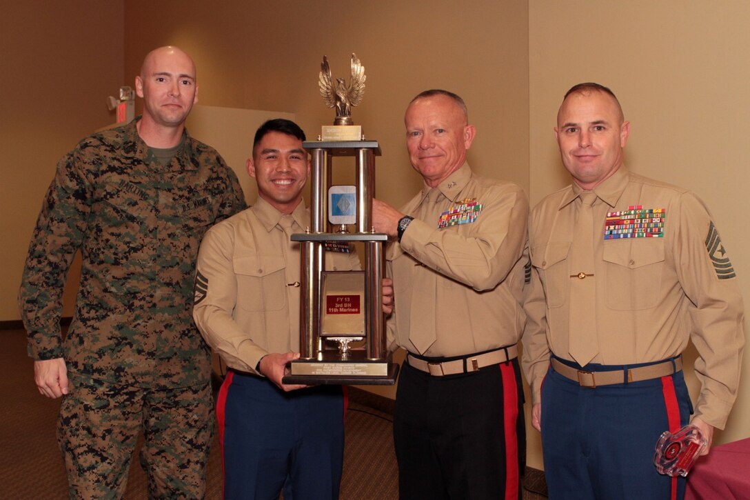 Marines with 1st Marine Division display the Inchon Trophy, which was awarded to Staff Sgt. Anourak D. Phavorachith, career planner, 3rd Battalion, 11th Marine Regiment, for outstanding achievements in 2013 during the 1st Marine Division Annual Career Planning Awards Luncheon at Marine Corps Base Camp Pendleton, Calif., Jan. 27, 2014. Pictured left to right: Sgt. Maj. Gregory D. Harding, battalion sergeant major, 3rd Bn., 11th Marines, Phavorachith, Maj. Gen. Larry D. Nicholson, 1st Marine Division commanding general, and Sgt. Maj. David L. Jobe, 1st Marine Division sergeant major. Phavorachith, a 30-year-old native of Fresno, and 2001 graduate of Hoover High School, is required to interview Marines in the battalion several times throughout their careers and assist them in reenlisting, transitioning successfully to a civilian career or pursuing higher education.  He is one of many career planners serving more than 25,000 combat-ready Marines and Sailors throughout 1st Marine Division. 
(U.S. Marine Corps photo by Sgt. Jacob H. Harrer / released)